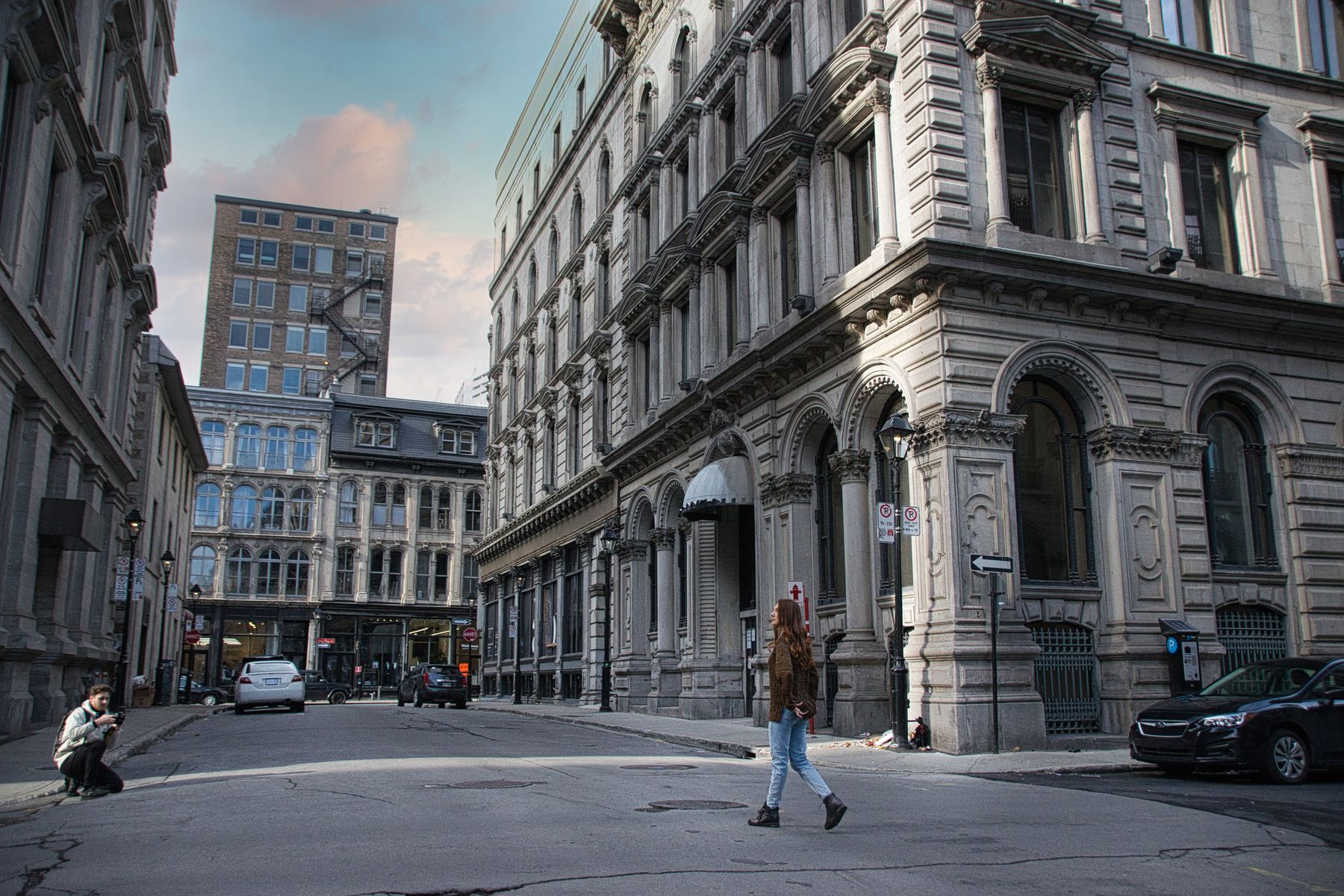 Grey stone commercial buildings with arched windows on a quiet street corner in Old Montréal