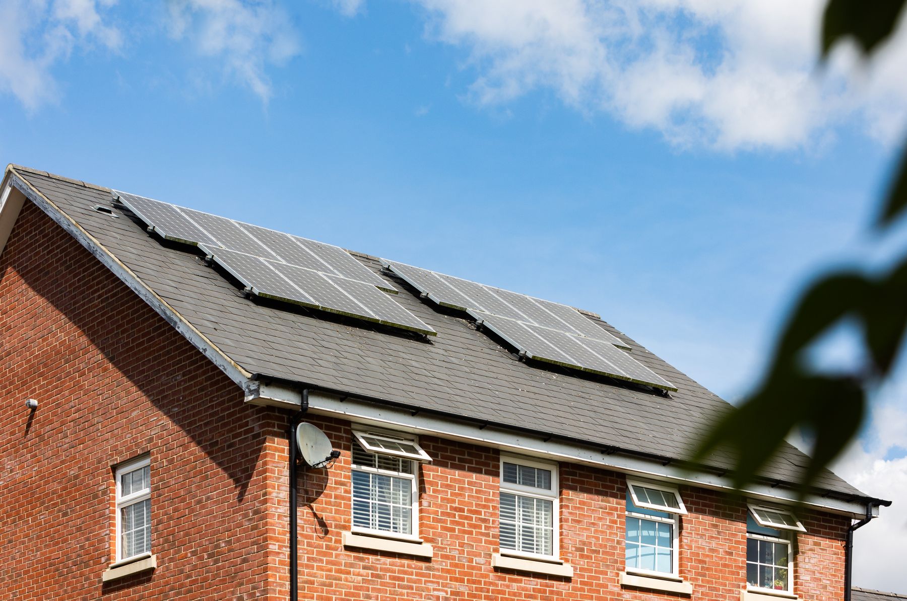 Solar panels on the slate roof of a brick building