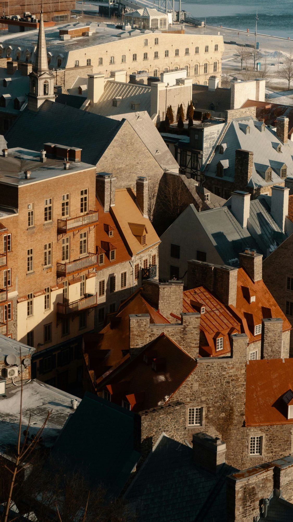 Stone buildings and steep metal roofs in Old Québec in low winter sun